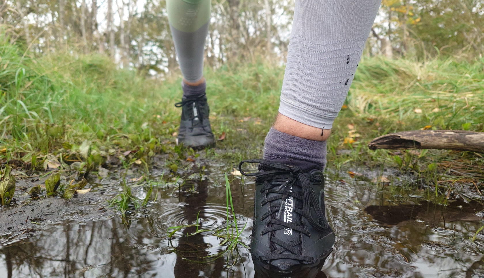 een persoon stapt in de modder met trailschoenen van the north face