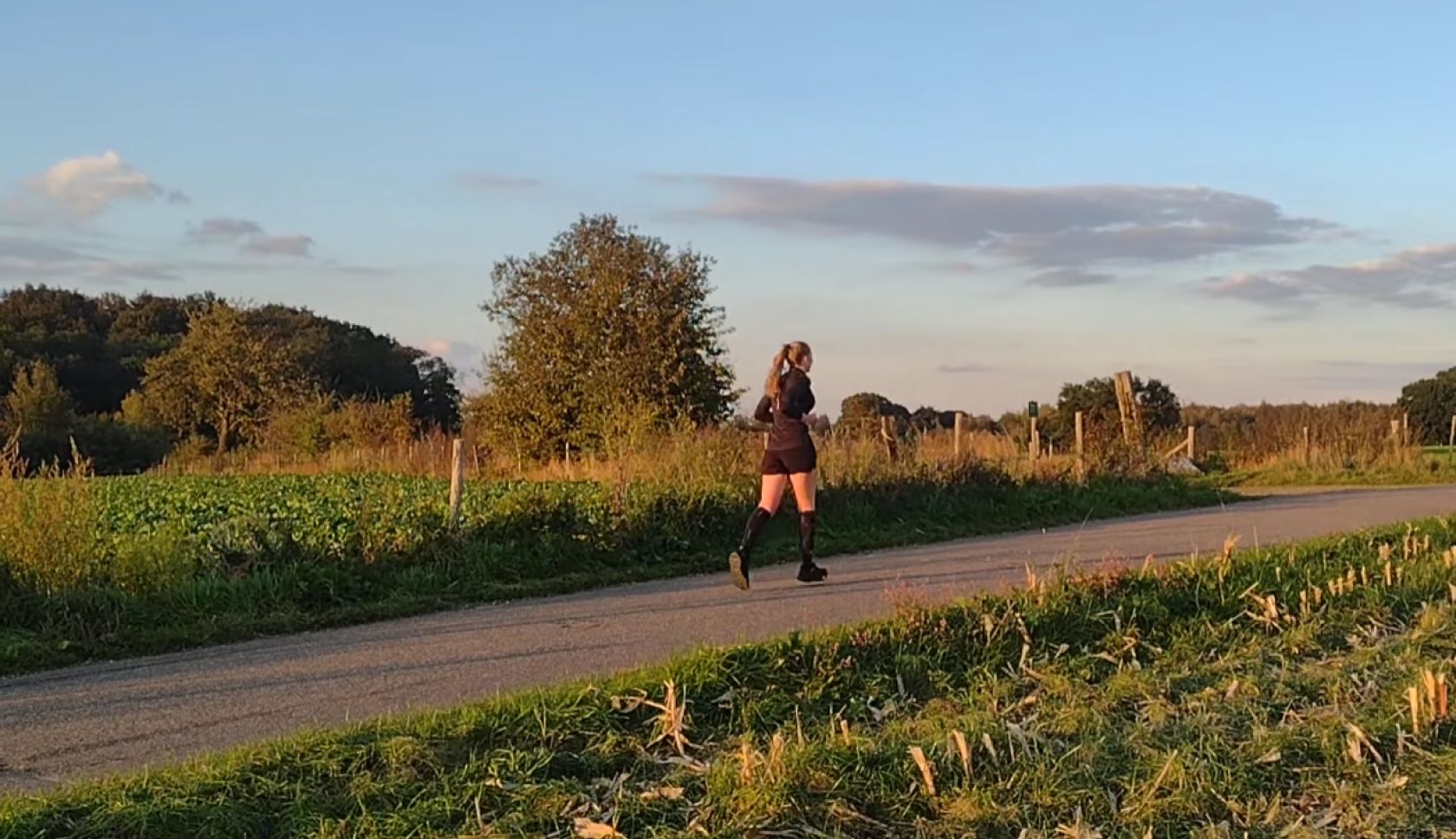 een vrouw rent op een geasfalteerde weg op het platteland