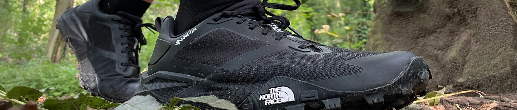 een zwarte trailschoen van the north face in de bossen