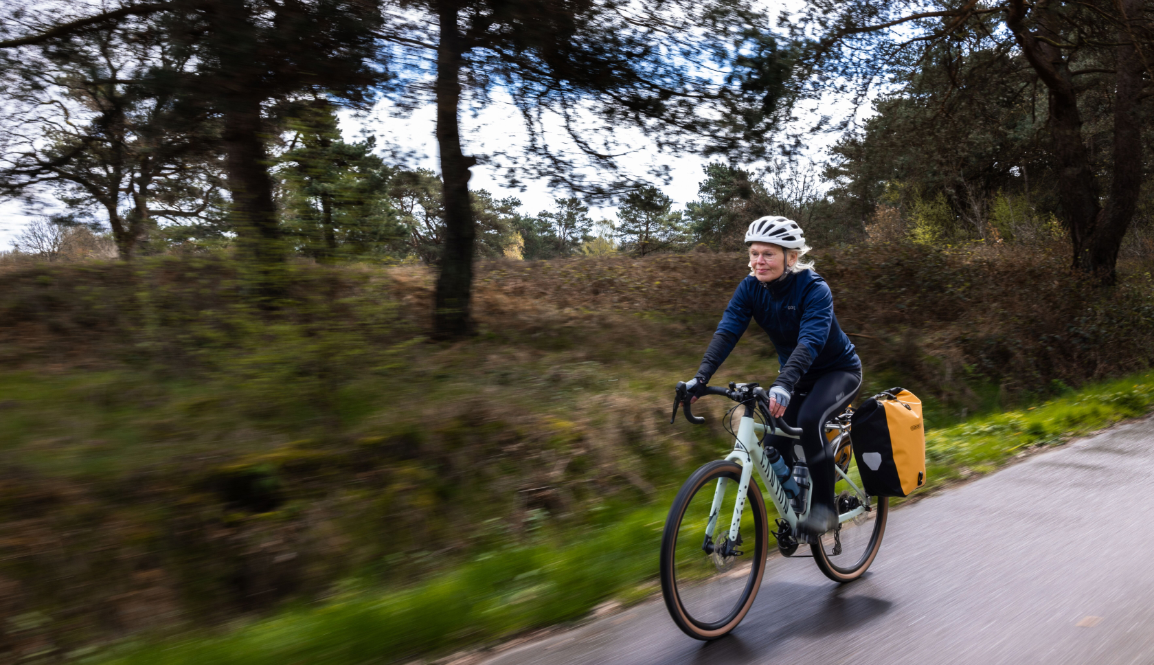 een oudere vrouw fietst in het zonnetje