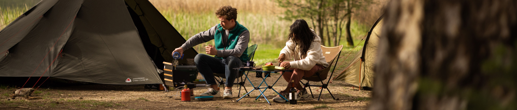 Een man en vrouw eten en drinken voor een tent