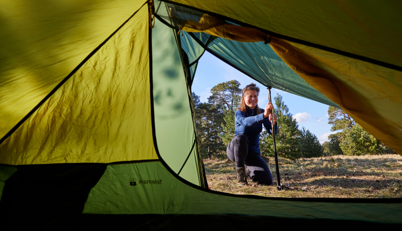 Een jonge vrouw zet de tent op in de bossen