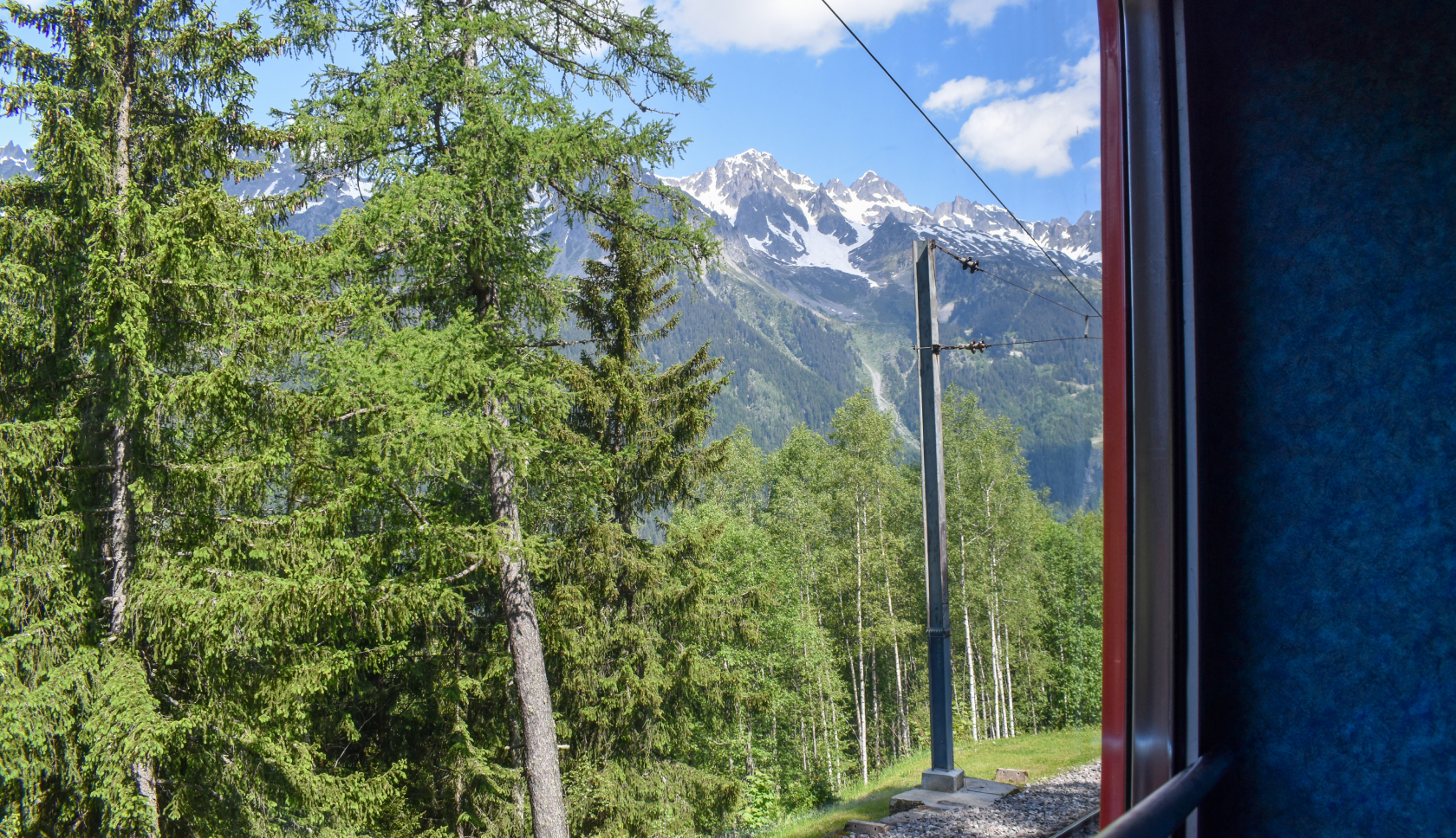 Uitzicht op de bergen en dennenbomen vanuit een trein