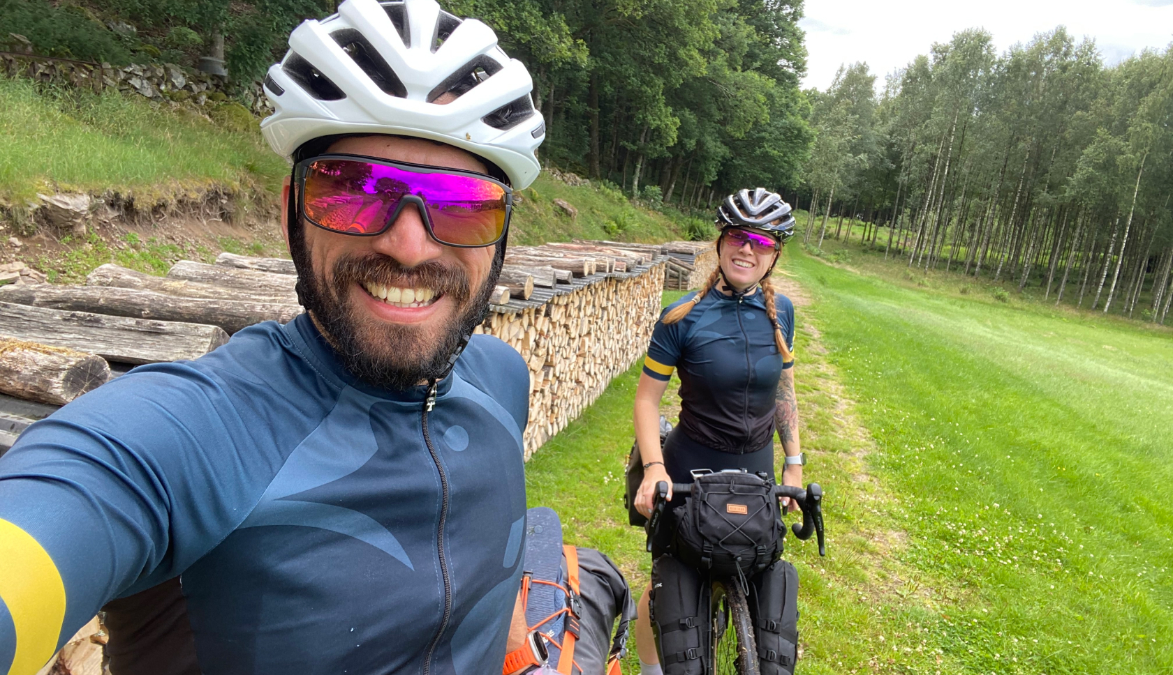 Een man en vrouw in fietskleding lachen in de camera