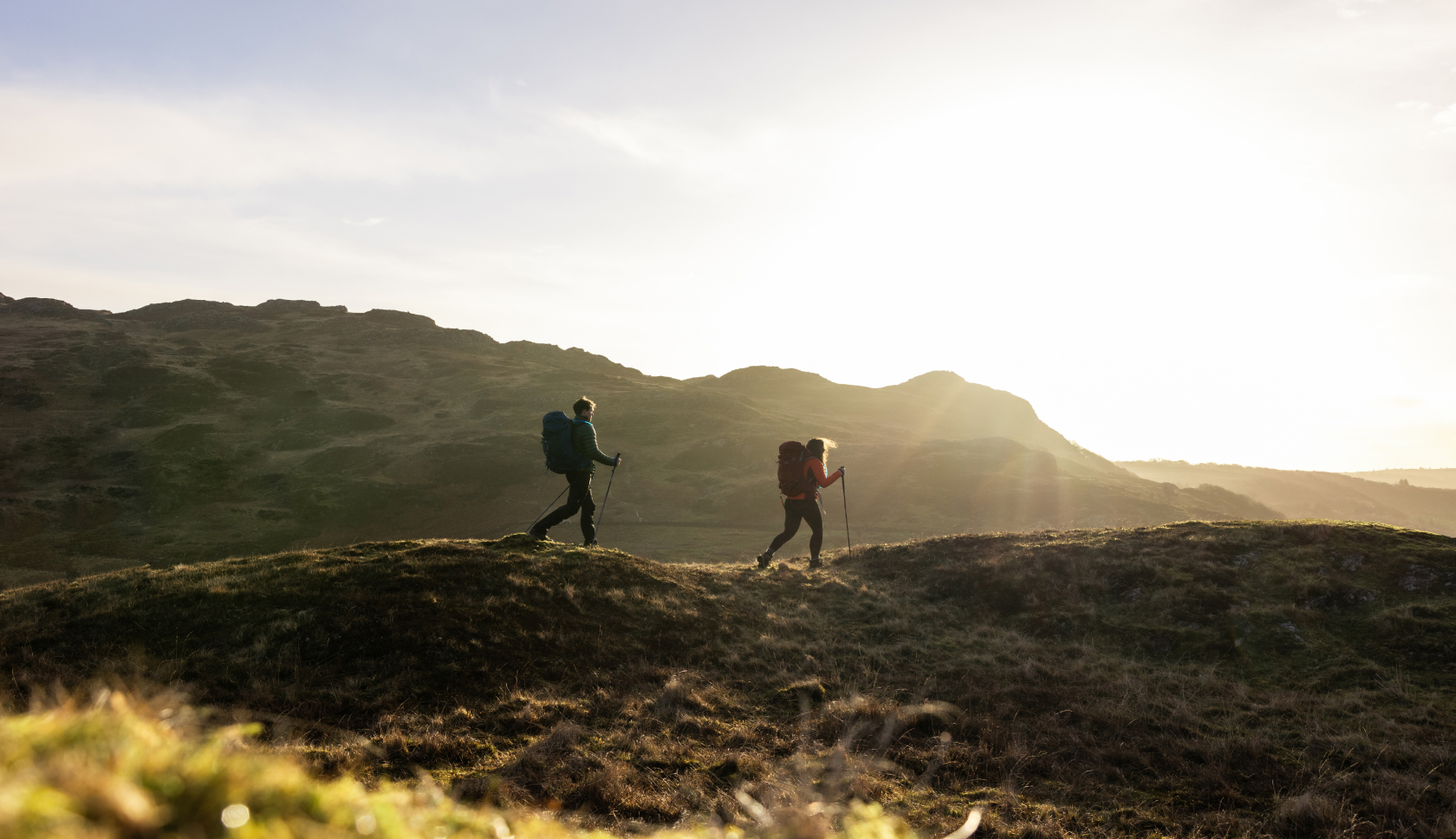 Twee personen lopen in een glooiend gebied