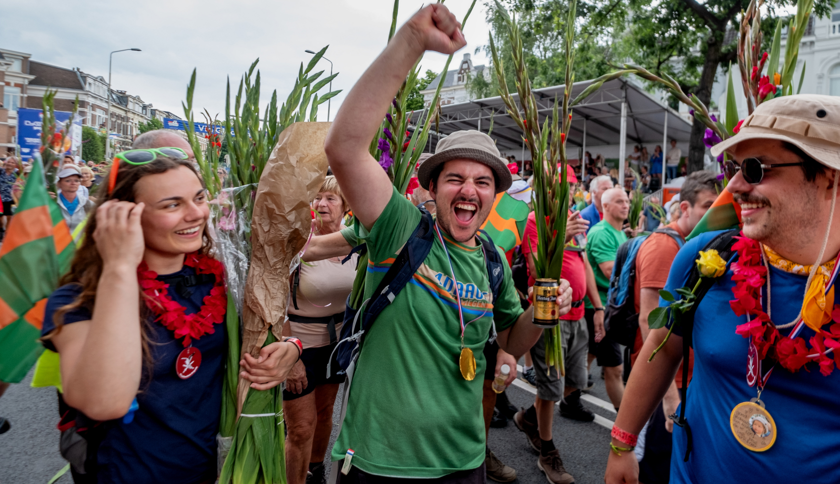 een groep wandelaars viert dat ze de Vierdaagse hebben uitgelopen