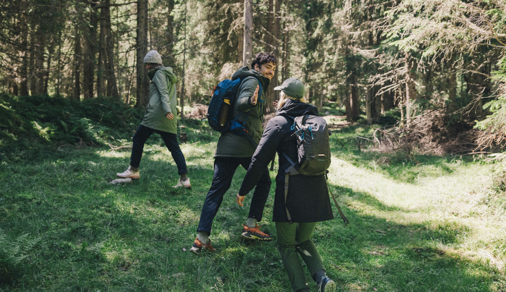 Drie vrienden lopen achter elkaar in een bos