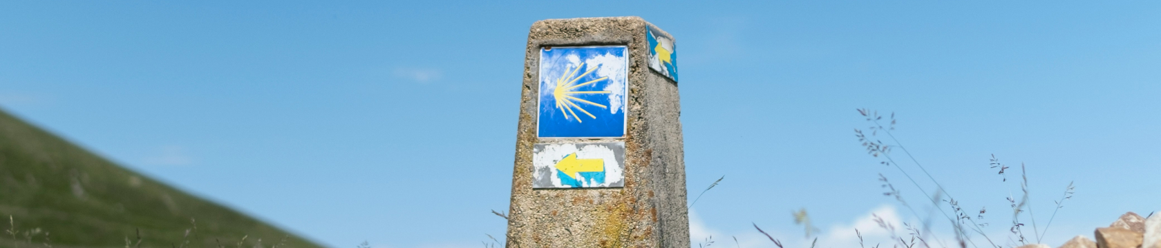 Een steen op een heuvel met een marker erop: het symbool van de camino de santiago