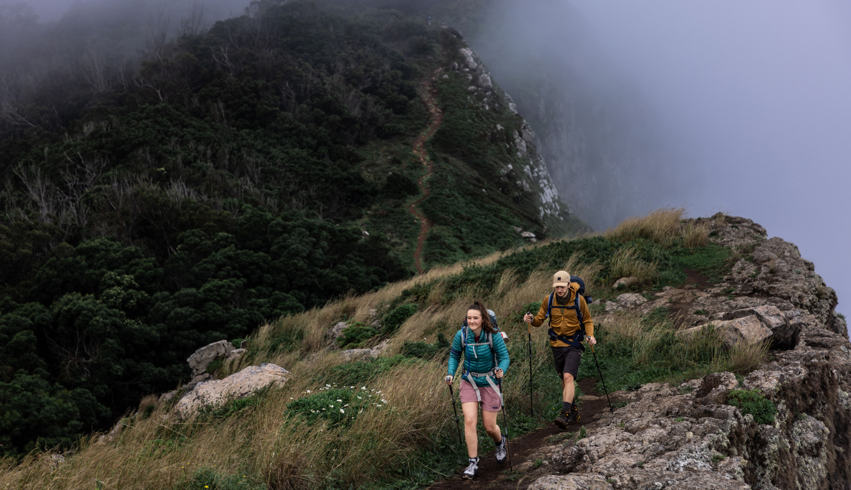 Een man en vrouw lopen door de mist in de bergen