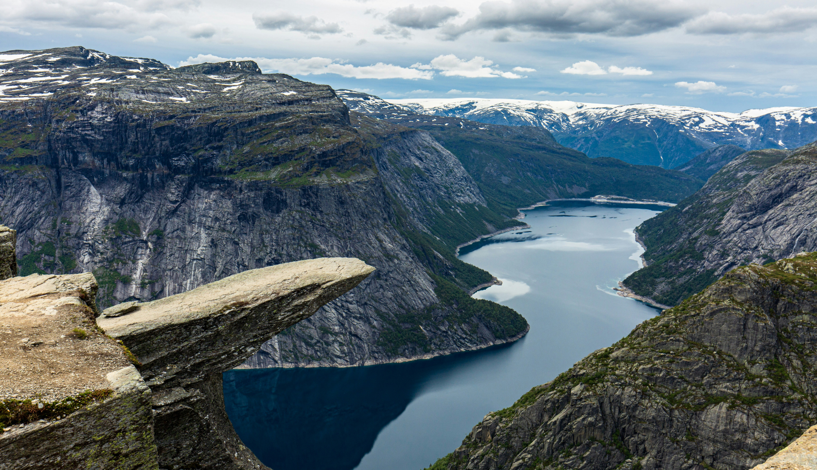 Een rotspiek zweeft hoog boven een Fjord