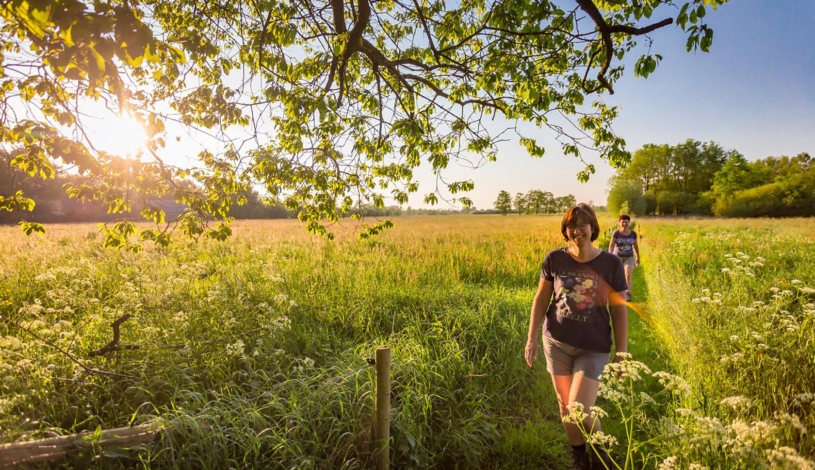 Twee wandelende vrouwen in een open grasveld