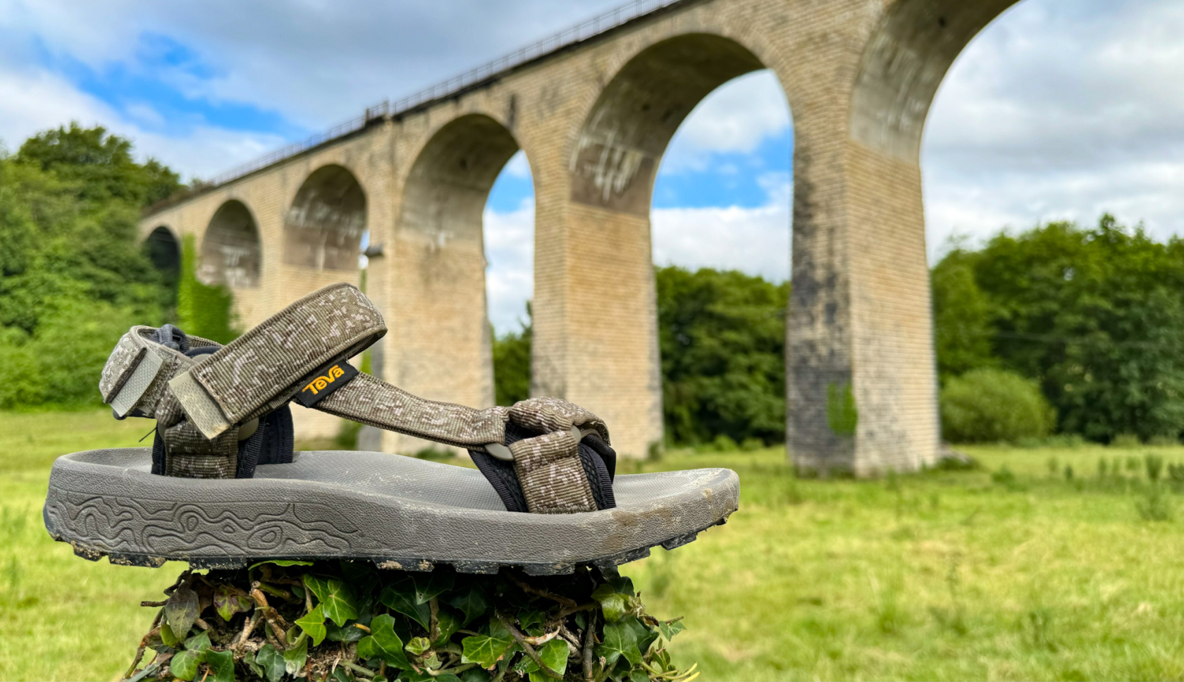 sandalen vanaf de voorzijde gefotografeerd, op de achtergrond staat een brug