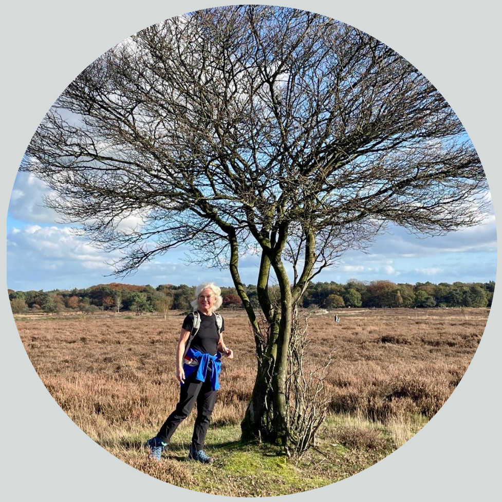 een vrouw staat naast een boom