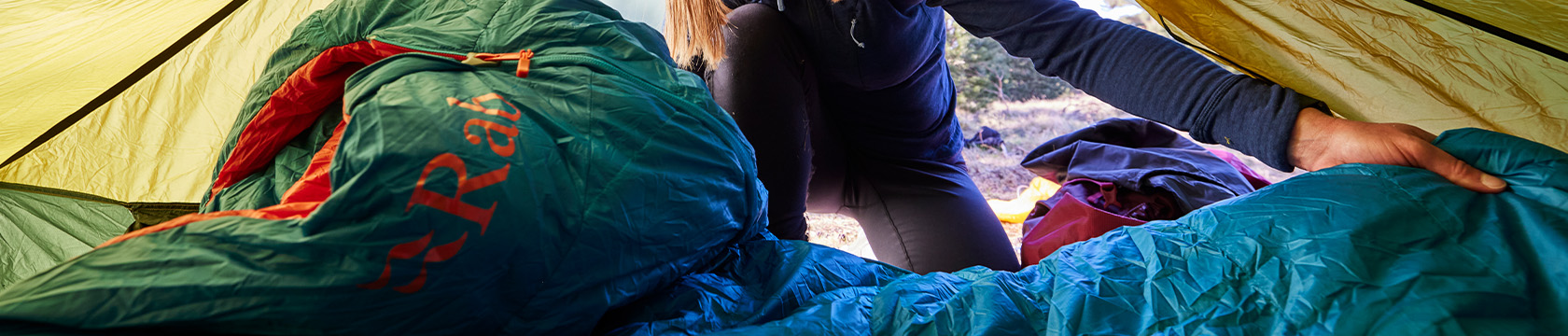 jonge vrouw legt haar slaapzak in haar tent