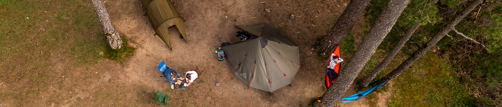 Groep mensen zit voor hun tent en genieten van de natuur