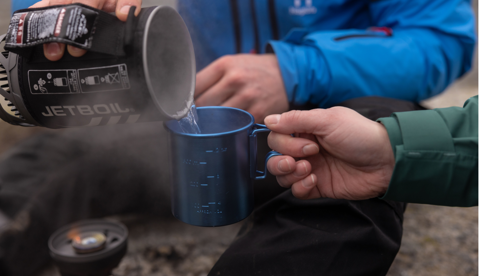 iemand schenkt gekookt water uit een Jetboil in een mokje