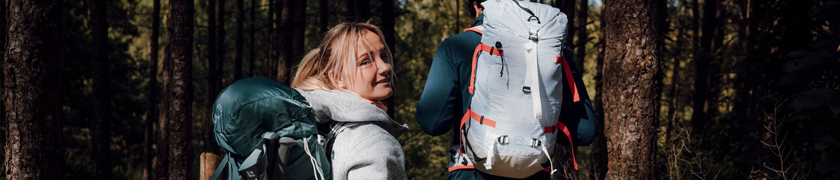 Twee wandelaars in het bos met een grote rugzak