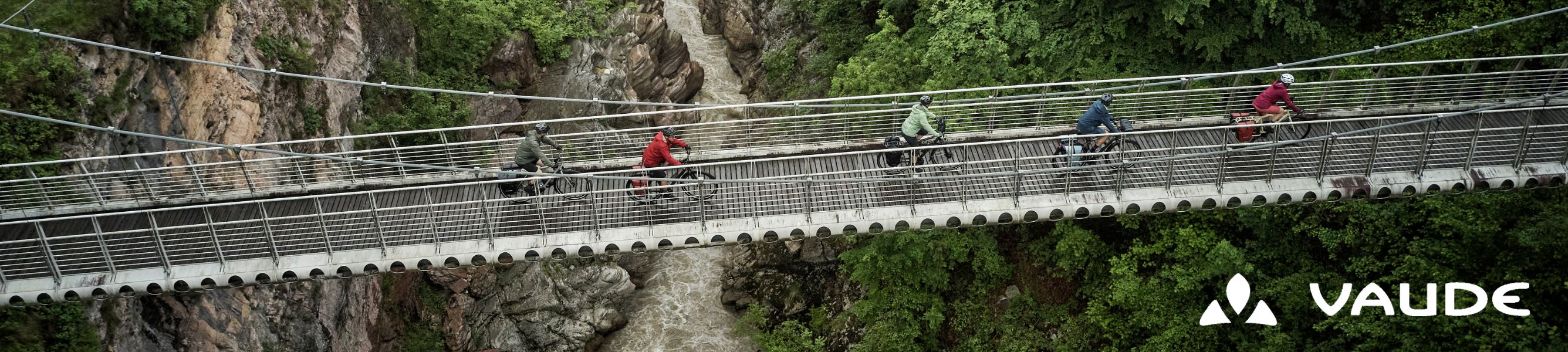  Een groep fietsers fietst over een hangbrug boven een rivier