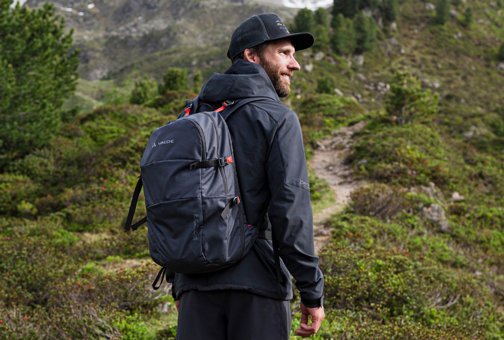 Man met VAUDE rugzak wandelt door een bergachtig landschap