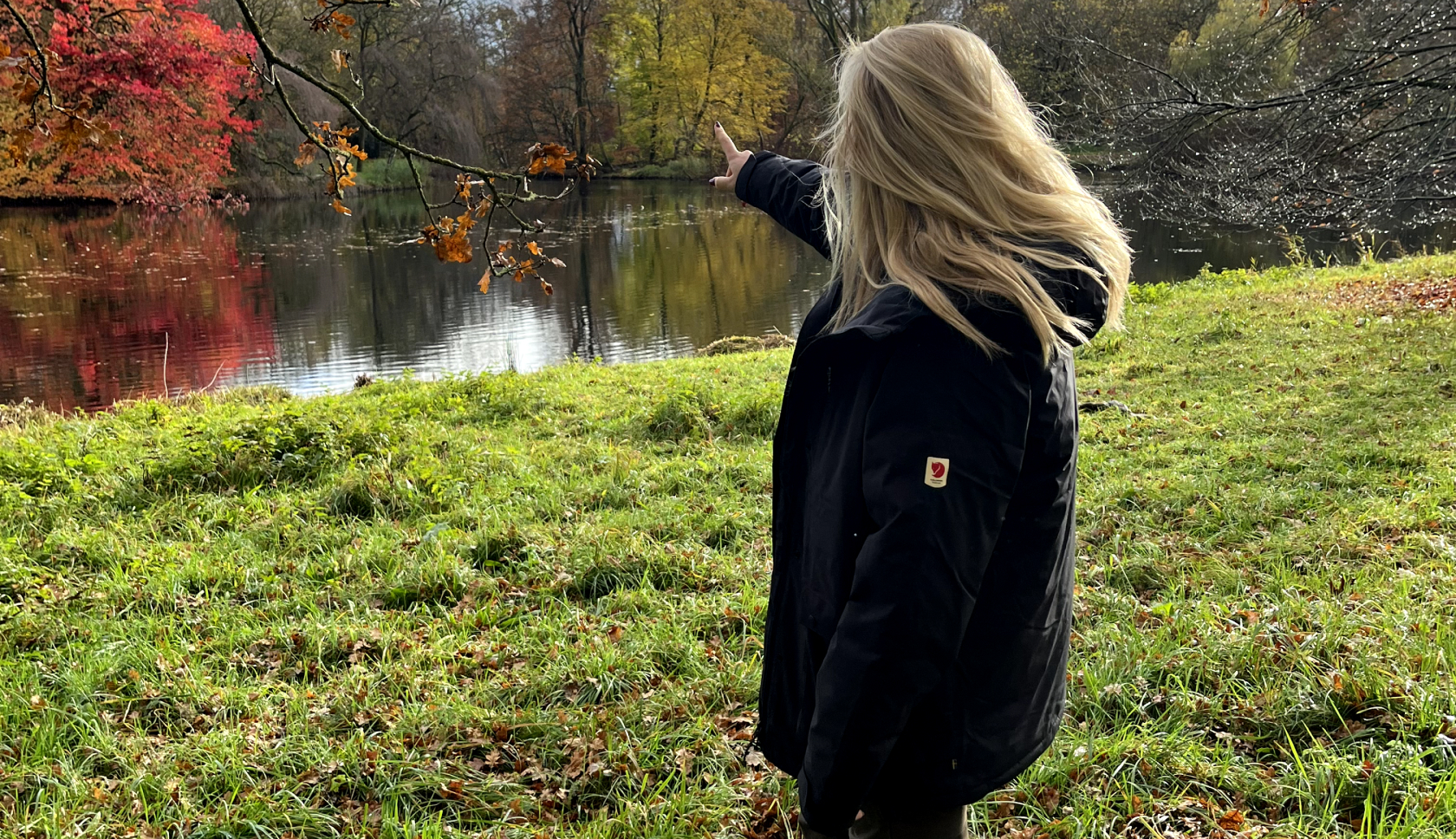 Een blauwe rugzak staat met het rugpand naar de camera in hoog gras